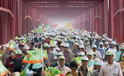 Nearly 10,000 Taiwanese gather on the old Hsilo Bridge during the island-wide human chain yesterday in Yunlin County, central Taiwan. The rally's supporters claim to have recruited at least 2 million people to form a human chain over 487km, extending from the northern port of Keelung to Pingtung County near the island's southern tip. Organizers and participants of ``Hand in Hand to Protect Taiwan'' hope the display of people power will focus global attention on the Chinese threat of nearly 500 missiles pointed at the nation.